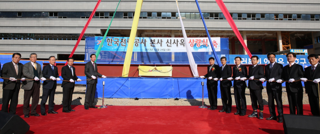Korea Electric Power Corp. CEO Cho Hwan-eik (fifth from left) and other participants attend the ceremony to mark the completion of the framework of the headquarters building under construction in Naju, South Jeolla Province, Tuesday. KEPCO plans to move to the city in November next year.   KEPCO