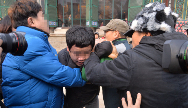 Supporters of the railway union strike push a plainclothes policeman out of Jogyesa Temple, the main temple of the Buddhist Jogye order, located in downtown Seoul, Wednesday. (Lee Sang-sub/The Korea Herald)