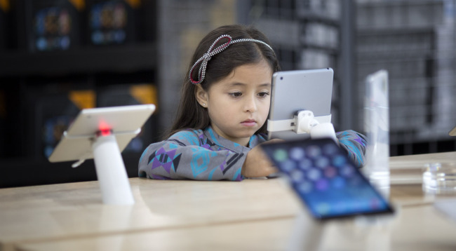 A child plays with an iPad at a shop in the U.S.   AP-Yonhap News