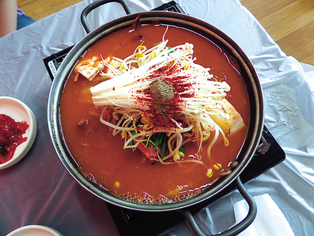 Kimchi jjigae is a spicy stew made with kimchi, tofu and slices of pork. The dish has often been unhelpfully described as “kimchi and bean curd soup” or just simply as “spicy Korean stew” in a number of establishments.   Claire Lee/The Korea Herald