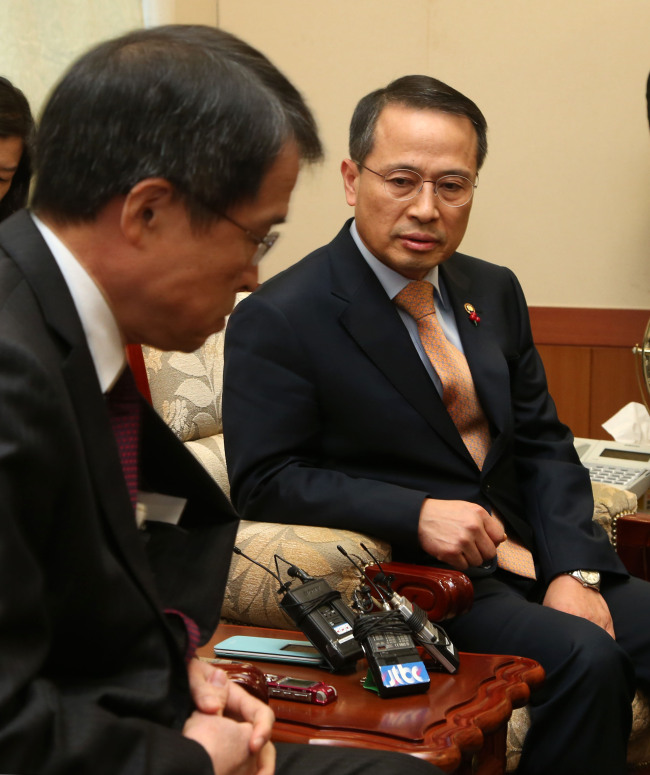 Vice Foreign Minister Kim Kyou-hyun (right) lodges a protest with Takashi Kurai, a minister and deputy chief of the Japanese Embassy in Seoul, over Japanese Prime Minister Shinzo Abe’s visit to the Yasukuni Shrine on Thursday.   Ahn Hoon /The Korea Herald