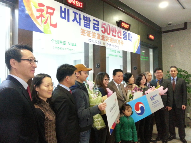 Consul General to Shanghai Gu Sang-chan (sixth from right) poses with a Shanghai resident (fifth from right) who was issued the consulate’s 500,000th visa in a ceremony to mark the milestone in Shanghai on Thursday.   Yonhap News