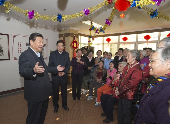 Chinese President Xi Jinping (left) talks with senior citizens at a nursing home in Beijing on Saturday.   Xinhua-Yonhap News