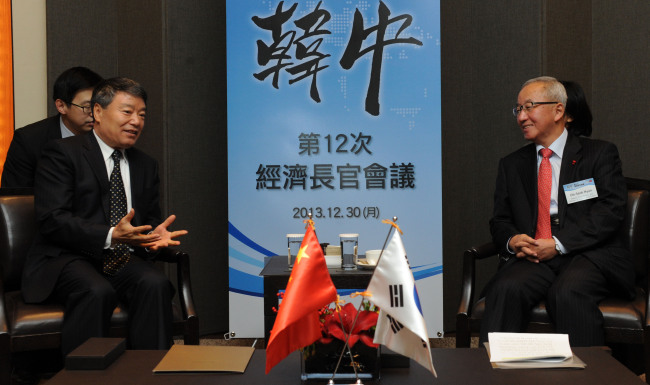 Korean Finance Minister Hyun Oh-seok (right) meets China’s National Development and Reform Commission chairman Xu Shaoshi in Seoul on Monday.   Lee Sang-sub/The Korea Herald