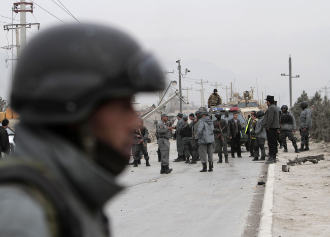 Afghan police and NATO forces respond to a suicide car bomb attack on the Jalalabad-Kabul road in Kabul.   AP-Yonhap News