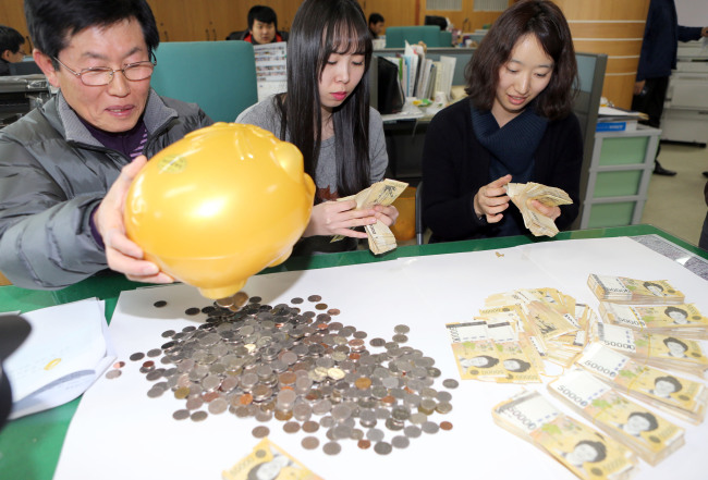 Employees of the Nosong-dong Community Center in Jeonju, North Jeolla Province, count money donated by an unidentified person in the center on Monday.   Yonhap News