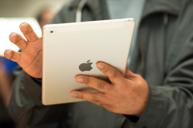 A customer tries out the new Apple Inc. iPad Air at the 5th Avenue Apple store in New York.   Bloomberg