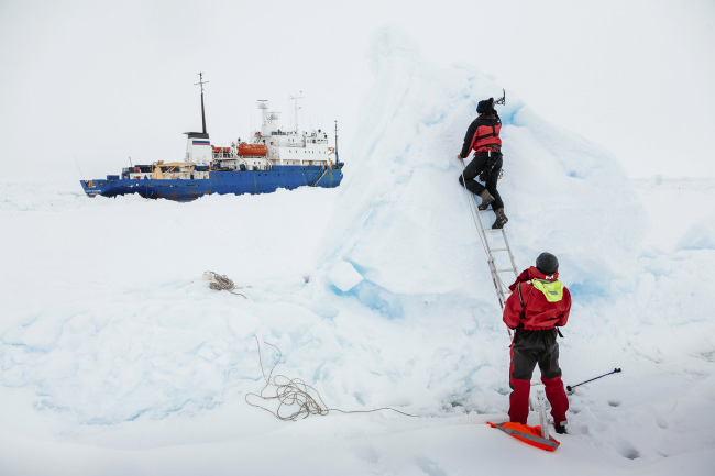 Ben Maddison and Ben Fisk from the Russian ship MV Akademik Shokalskiy work to place a wind indicator atop an ice feature near the trapped ship 2,800 kilometers south of Hobart, Australia, Tuesday.   AP-Yonhap News