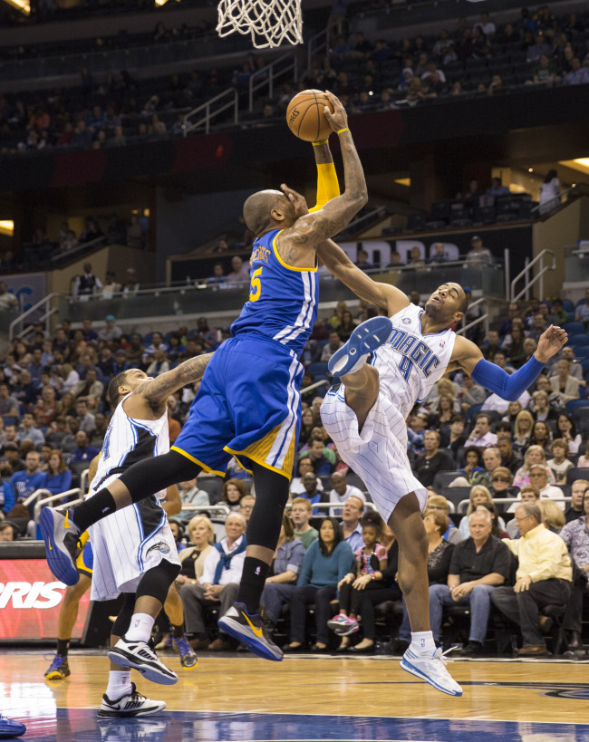 Golden State Warriors Marreese Speights (center) fights for the rebound with Orlando Magic’s Arron Afflalo during the second half of an NBA basketball game in Orlando, Florida, Tuesday.  AP-Yonhap News