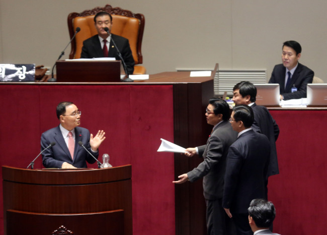 Democratic Party lawmakers propose an adjournment to Prime Minister Jung Hong-won (left) at the National Assem­bly in the early hours of Wednesday. Members of parliament later passed the long-awaited National Intelligence Service reform bill along with key budgetary legislation as the clock ticked past midnight on New Year’s Eve.   Yonhap News