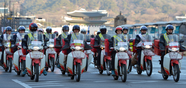 Some 50 postmen from the Gwanghwamun Post Office take part in a parade to celebrate the New Year on a road near Seoul Plaza on Thursday.   Yoon Byung-chan/The Korea Herald