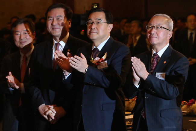 Finance Minister Hyun Oh-seok (right) and Financial Services Commission chairman Shin Je-yoon (second from left) applaud during a New Year’s ceremony at Lotte Hotel in downtown Seoul hosted by the country’s top financial companies.   Yonhap News