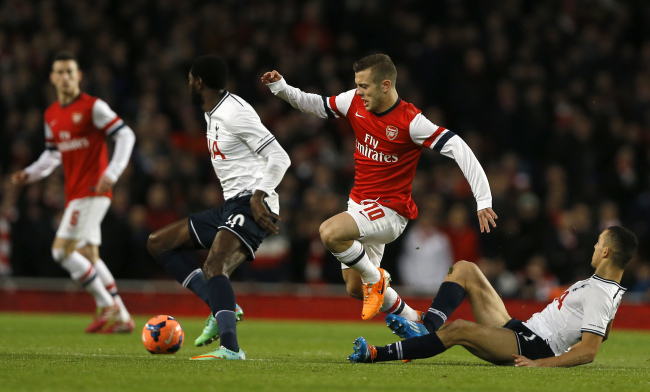 Arsenal’s Jack Wilshere (second from right) steps over a challenge from Tottenham’s Nabil Bentaleb (right) at the Emirates Stadium in London on Saturday.     AP-Yonhap News