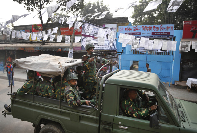 Bangladeshi army soldiers patrol on a street during election in Dhaka on Sunday.   AP-Yonhap News