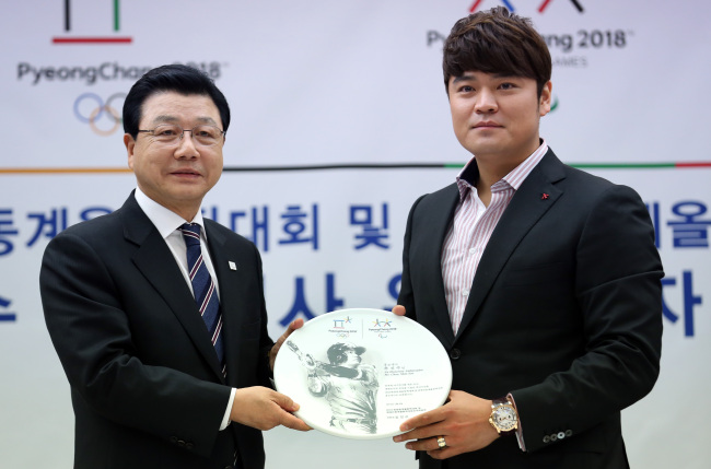 Texas Rangers outfielder Choo Shin-soo (right) poses with Kim Jin-sun, head of the 2018 PyeongChang Winter Olympics organizing committee, after being named a goodwill ambassador for the Winter Games in Seoul on Monday.   Yonhap News
