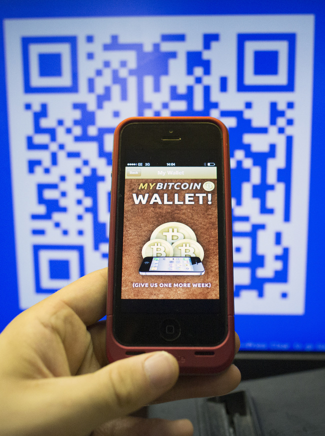 An iPhone 5 displays the Bitcoin Wallet smartphone app in London.   Bloomberg