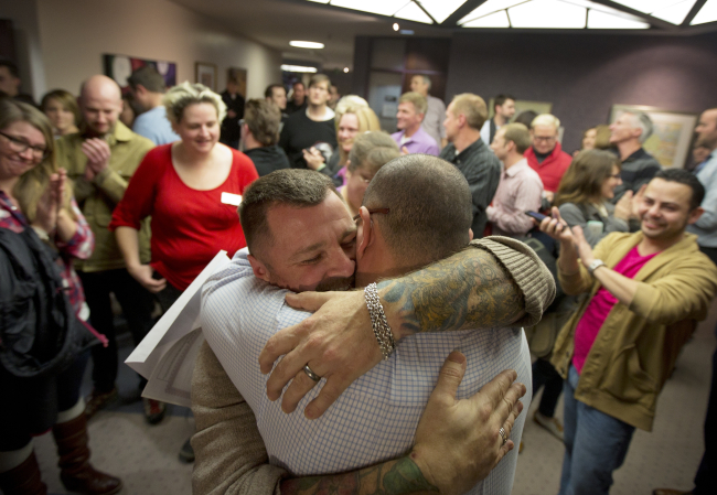 In this Dec. 20 file photo, Chris Serrano (left) and Clifton Webb embrace after being married, as people wait in line to get licenses outside of the marriage division of the Salt Lake County Clerk’s Office in Salt Lake City, Utah.
AP-Yonhap News