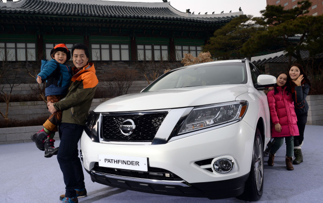 Models pose with the Nissan Pathfinder, the company’s premium seven-seater SUV, at a launch event in Seoul on Tuesday.   Ahn Hoon/The Korea Herald