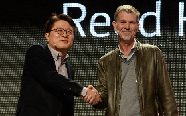 LG Electronics chief technology officer Ahn Seung-kwon (left) shakes hands with Reed Hastings, chief executive of Netflix during a press conference by LG Electronics at the International CES in Las Vegas on Monday, where the company unveiled a smart TV made easier with the WebOS.   LG Electronics