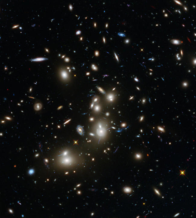 This undated image shows galaxies in the Abell 2744 cluster, and blue galaxies behind it, distorted and amplified by gravitational lensing.   AP