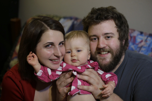 Amanda Leigh Pulte (left) and Matthew Gage (right) pose with their daughter Zoey at their home in San Antonio on Dec. 20.   AP-Yonhap News