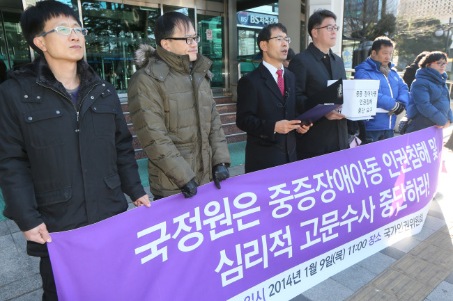 Lawyer Oh Young-joong (third from left) accuses the National Intelligence Service of psychologically torturing a suspect and violating the rights of a disabled minor outside the National Human Rights Commission in Seoul on Thursday.   Yonhap News