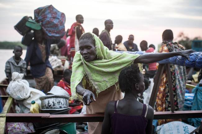 Hundreds of civilians fleeing violence in the Bor region arrive at one of the many small ports that run alongside the camps in the Awerial region, South Sudan, Thursday.    AFP-Yonhap News