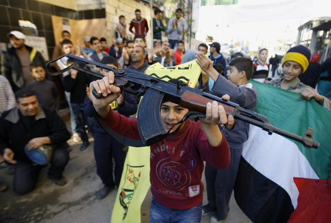 Palestinians dance after hearing that Ariel Sharon, the hard-charging Israeli general and prime minister, died, as they celebrate in the Ein el-Hilweh camp near the southern city of Sidon, Lebanon, Saturday.   AP-Yonhap News