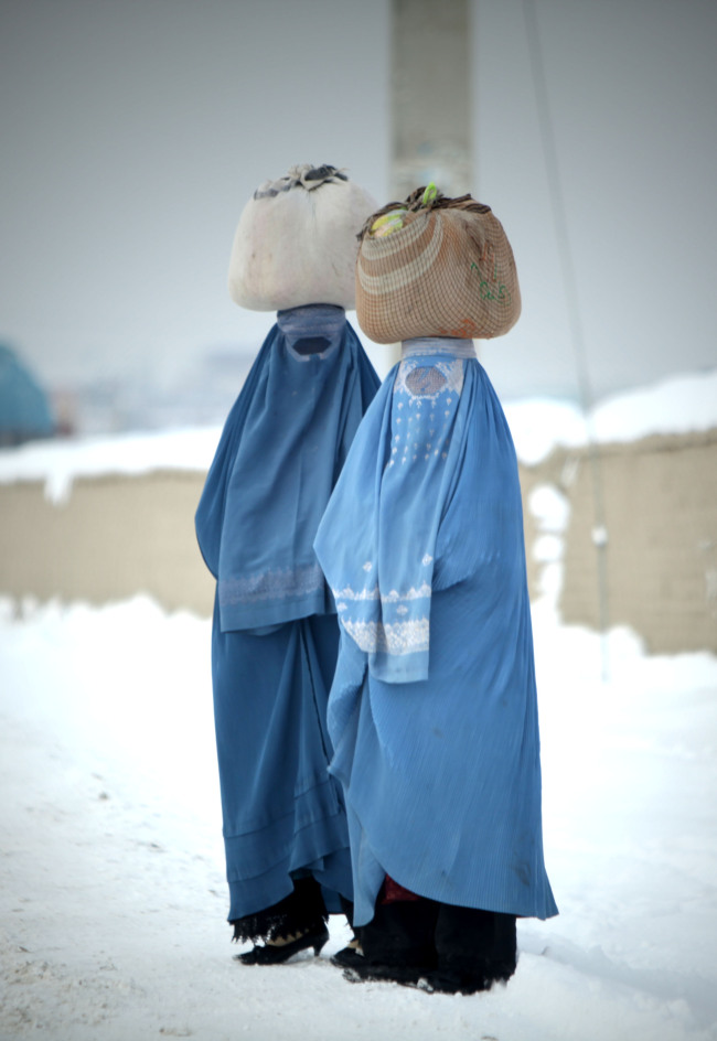 Afghan women wait for a bus in the snow in Kabul, capital of Afghanistan, Dec. 30.   Xinhua-Yonhap News