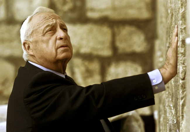 In this Feb. 7, 2001, file photo, Ariel Sharon looks up as he touches Judaism’s holiest site, the Western Wall.   AP-Yonhap News