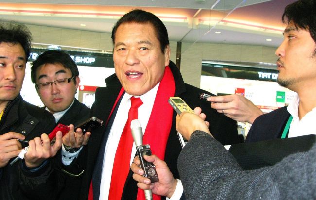 Japanese professional wrestler-turned-lawmaker Antonio Inoki (center) is surrounded by reporters upon his departure at Haneda Airport in Tokyo on Sunday.   AFP-Yonhap News