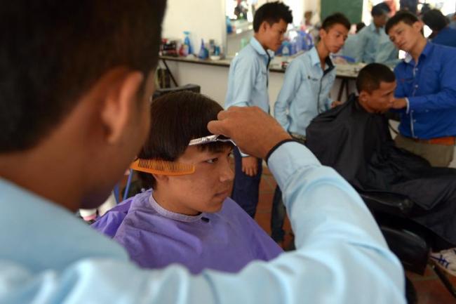 Deaf Cambodian students train at a hairdresser’s shop in Phnom Penh.   AFP