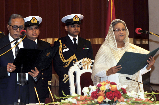 Bangladesh’s President Abdul Hamid (left) administers the oath to Prime Minister Sheikh Hasina (right) during her swearing-in ceremony in Dhaka on Sunday.
AP-Yonhap News