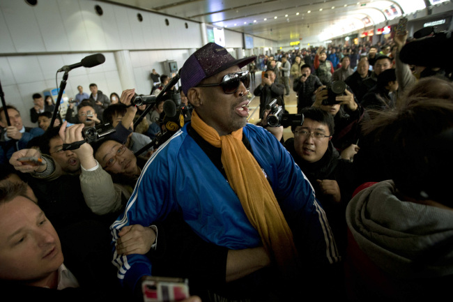 Former NBA basketball player Dennis Rodman is followed by journalists as he arrives at the Capital International Airport in Beijing from Pyongyang, Monday.   AP-Yonhap News