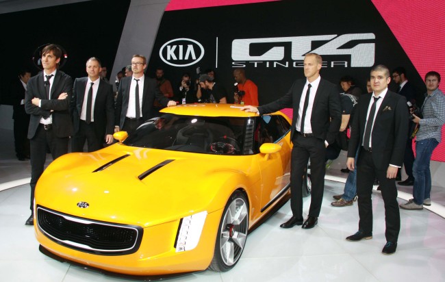 Kia Motors America’s chief designer Tom Kearns (left) and his team members pose with the carmaker’s concept sports car, the GT4 Stinger, at the North American International Auto Show in Detroit on Monday.   Kia Motors