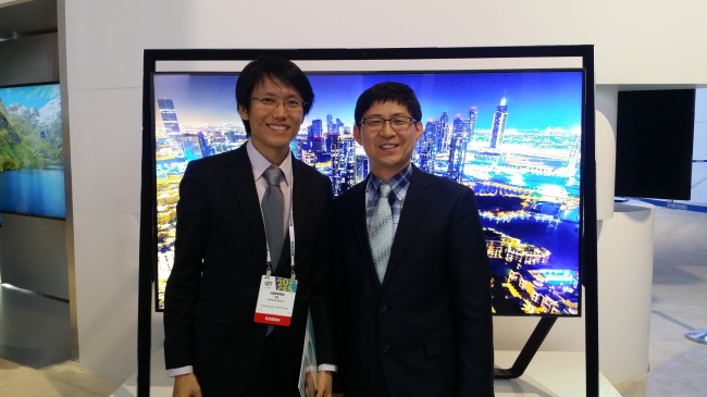Yi Jason (left), managing director of Haesung Optics, and Kang Min-goo, an outside director of the firm, pose at Samsung Electronics’ exhibition venue at the 2014 International CES in Las Vegas last week.