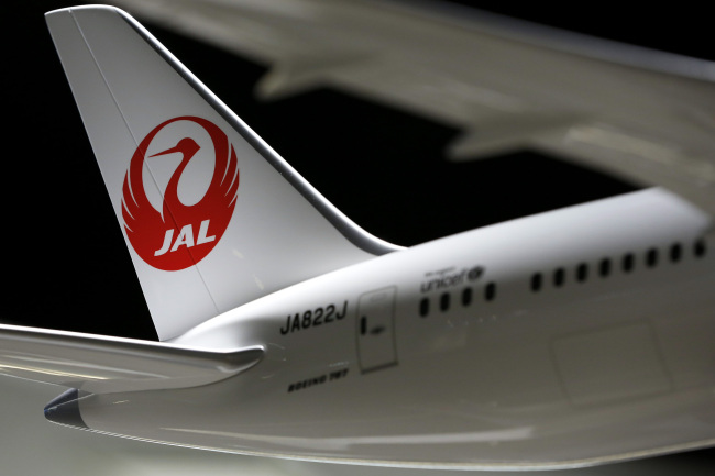 The Japan Airlines Co. logo sits on the tailfin of a model of the Boeing Co. 787 Dreamliner aircraft.   Bloomberg