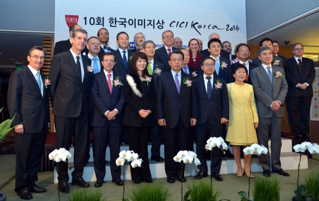 Choi Jung-hwa (front row, second from right), president of the Corea Image Communication Institute, Lee Don-joo (front row, third from right), president of mobile phone operations at Samsung Electronics, and jazz vocalist Nah Youn-sun (front row, fourth from left) pose with delegates and foreign envoys during CICI Korea 2014 in Seoul on Wednesday.   Yoon Byung-chan/The Korea Herald