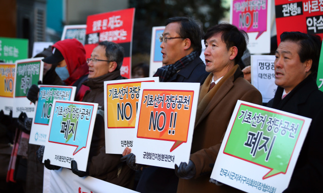 Activists supporting the abolition of the candidate nomination system for local elections call on the ruling Saenuri Party to follow through with President Park Geun-hye’s campaign pledge outside the party’s office in Seoul on Monday.   Yonhap News