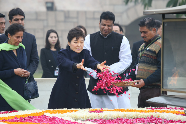 President Park Geun-hye leaves flowers on Mahatma Gandhi’s grave in New Delhi during her four-day state visit to India on Friday.   Yonhap News