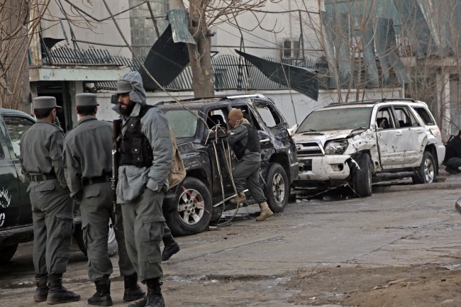 Afghan security forces personnel investigate the site of Friday’s suicide attack and shooting in Kabul on Saturday.   AP-Yonhap News