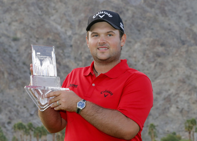 Patrick Reed poses with the winner’s trophy on Sunday.   AP-Yonhap News