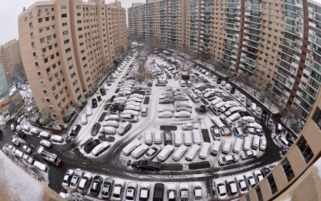 Cars covered in snow are parked at an apartment complex in southern Seoul on Monday. Starting late Sunday night, between 1 and 8 centimeters of snow fell across the country.   Lee Sang-sub/The Korea Herald