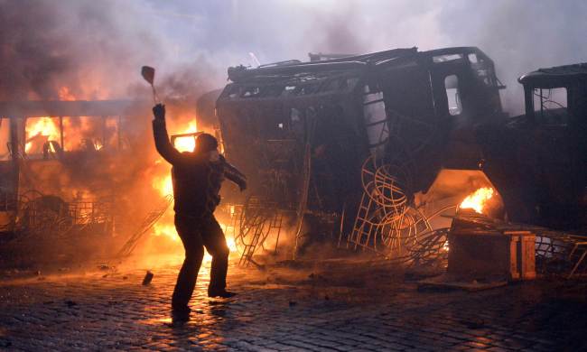 A protester throws stones during clashes with police in the center of Kiev on Monday.   AFP-Yonhap News