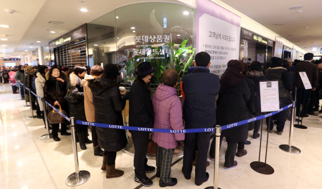 Customers line up to have their credit cards reissued to prevent losses from a leak of personal data at the Lotte Card Center in a branch of Lotte Department Store in Seoul on Tuesday. Yonhap News