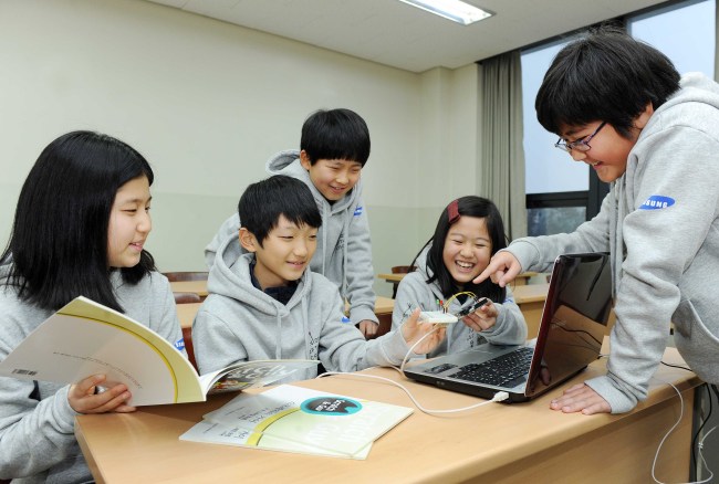 Children work together on software programming projects at the four-day Junior Software Camp, hosted by Samsung Electronics at Korea University’s Sejong campus, that opened on Sunday.   Samsung Electronics