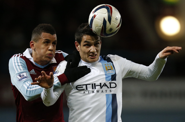 Marcos Paulo Mesquita Lopes (right) of Manchester City heads the ball with Ravel Morrison of West Ham United at Upton Parkin London on Tuesday.   Xinhua-Yonhap News