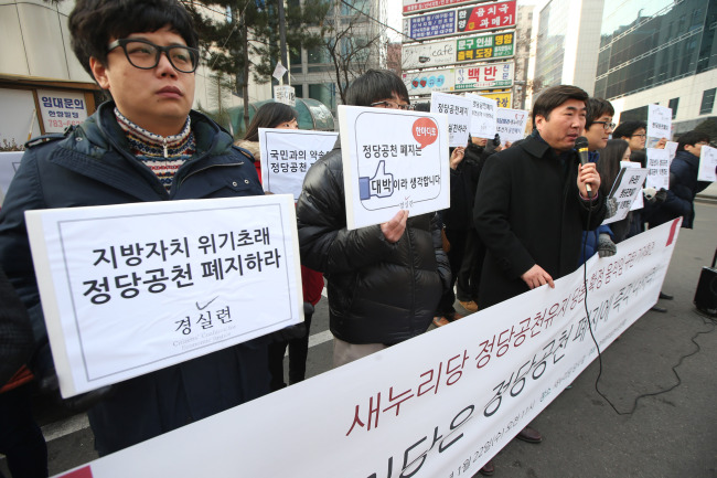 Members of the nongovernmental group Citizens’ Coalition for Economic Justice hold a rally calling for the abolishment of the candidate nomination system outside the Saenuri Party’s office in Seoul on Wednesday.   Yonhap News
