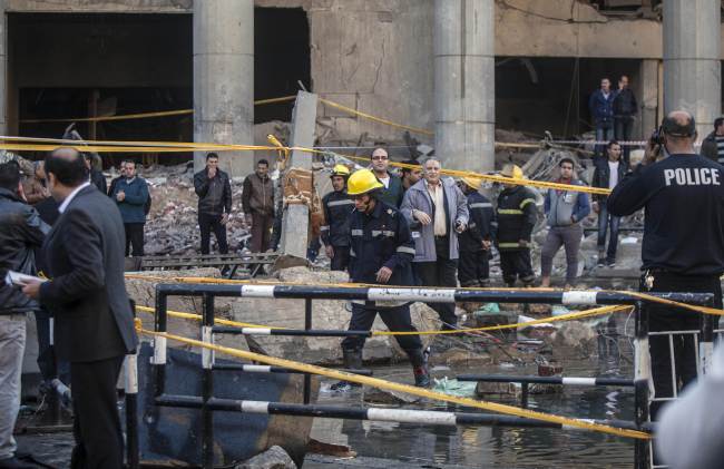 Egyptian emergency personnel and civilians inspect the site of a bomb explosion outside the Cairo police headquarters on Friday.   AFP-Yonhap