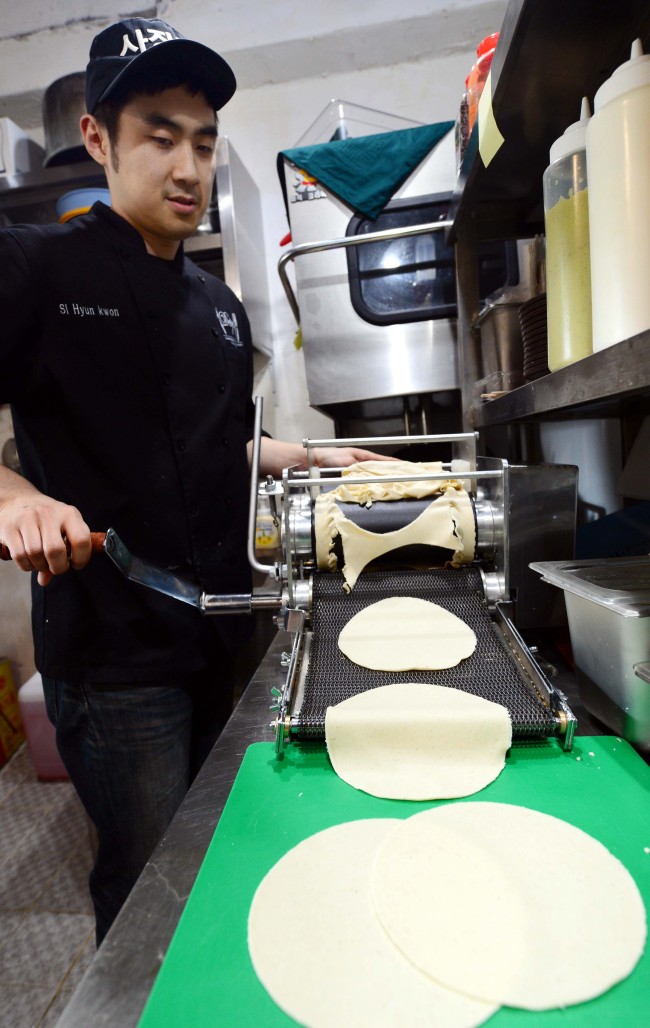At Paco Loco, corn masa flour dough is hand-cranked through a tortilla press to create the eatery’s toothsome tortillas. Kim Myung-sub/The Korea Herald
